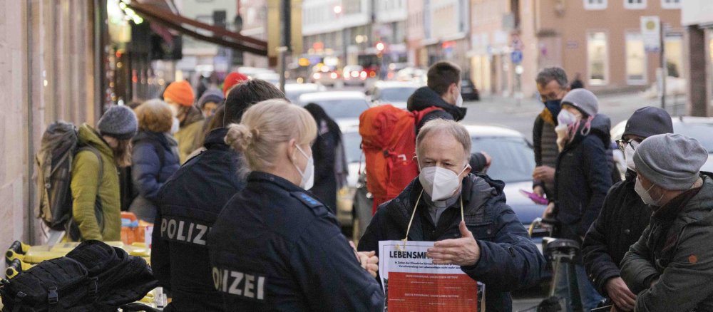 Jesuitenpater Jörg Alt unterhält sich mit Polizisten in der Nürnberger Innenstadt