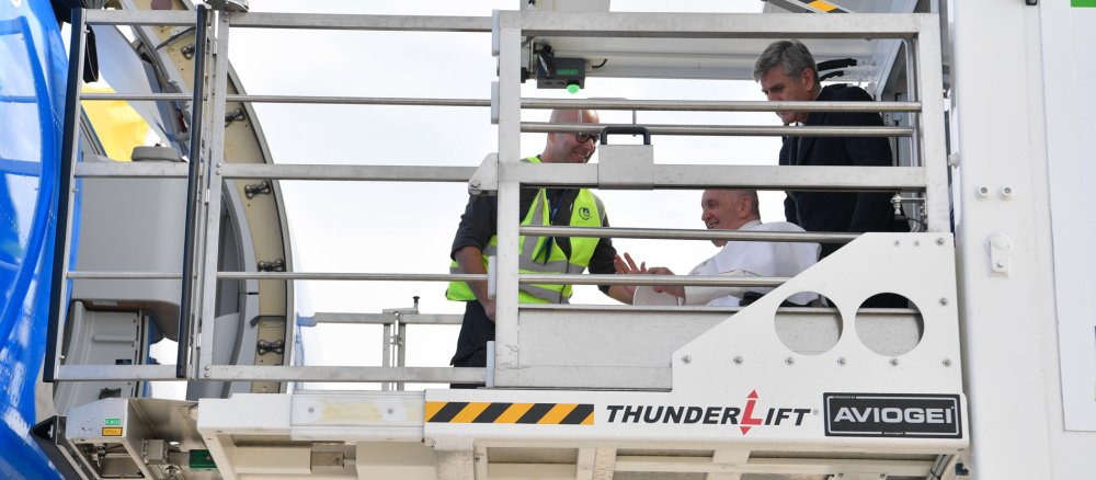 Der päpstliche Kammerdiener schiebt Papst Franziskus im Rollstuhl in ein Flugzeug