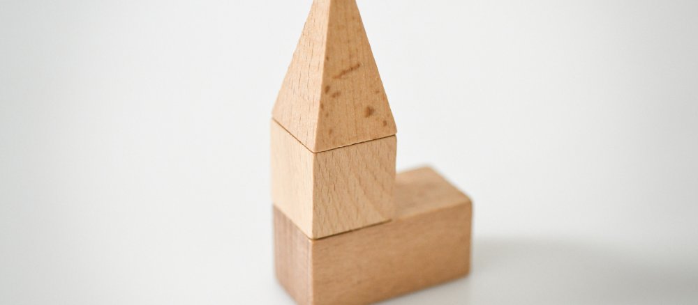 Bauklötze aus Holz sind zu einer Kirche gestapelt.