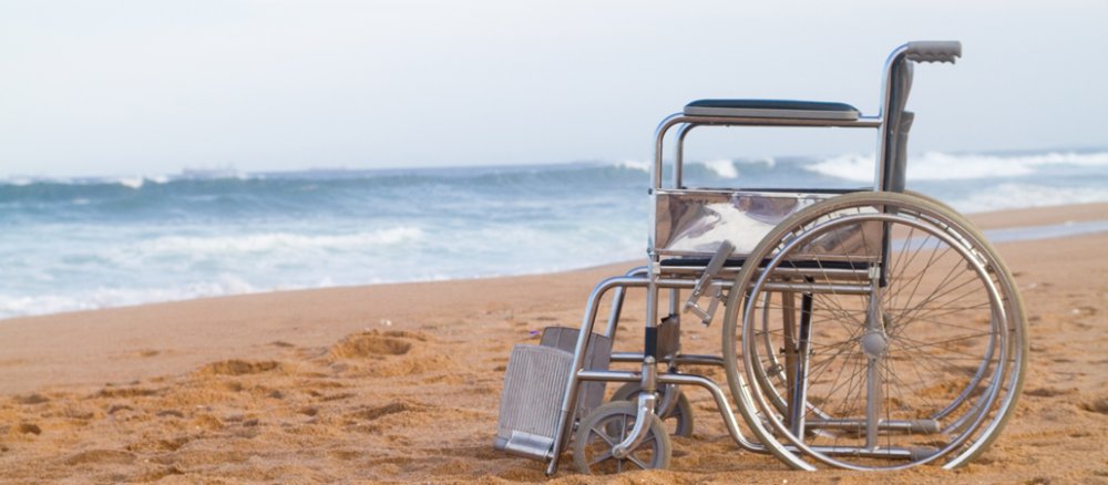 Leerer Rollstuhl am Strand