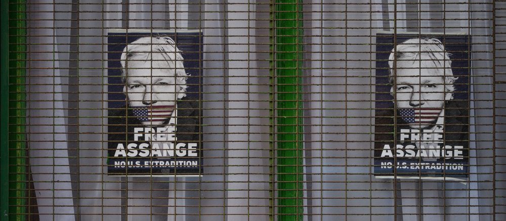 Poster mit der Aufschrift "Free Assange/No U.S. Extradition" ("Befreit Assange, keine Auslieferung an die USA") in einem Fenster.