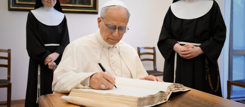 Papst Leo XIV. schreibt in ein großes Buch