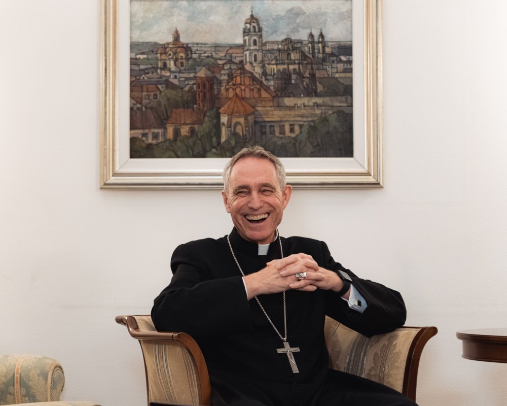 Erzbischof Georg Gänswein sitzt in einem Sessel und lacht