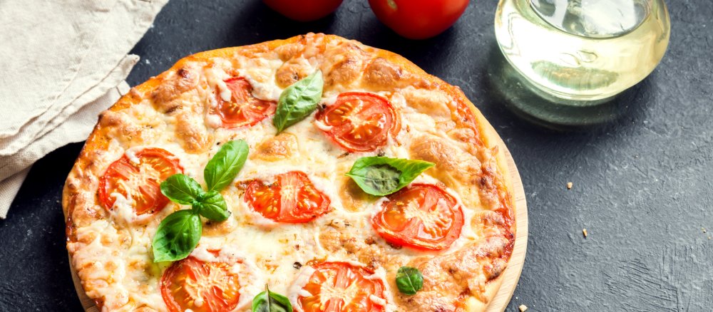 Eine Pizza Margherita mit Tomaten, Käse und Basilikum.