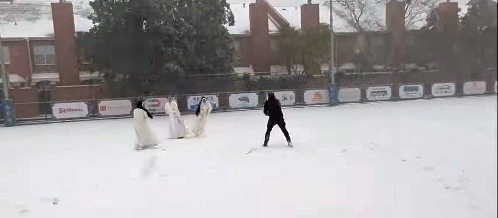 Drei Dominikanerinnen und ein Priester bei einer Schneeballschlacht