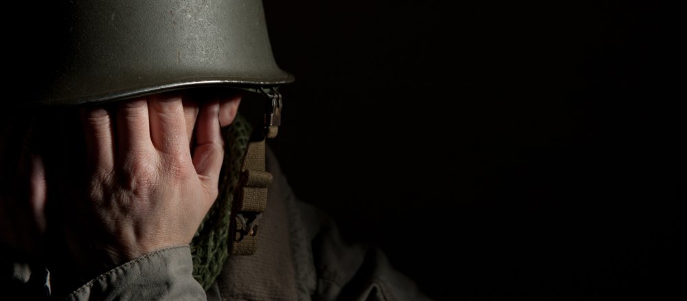 Ein Soldat hält sich die Hände vors Gesicht.