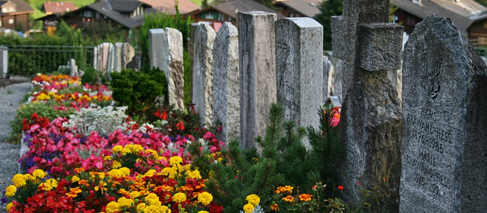 Mit Blumen geschmückte Friedhofsgräber zeugen von einer gelebten Erinnerungskultur.