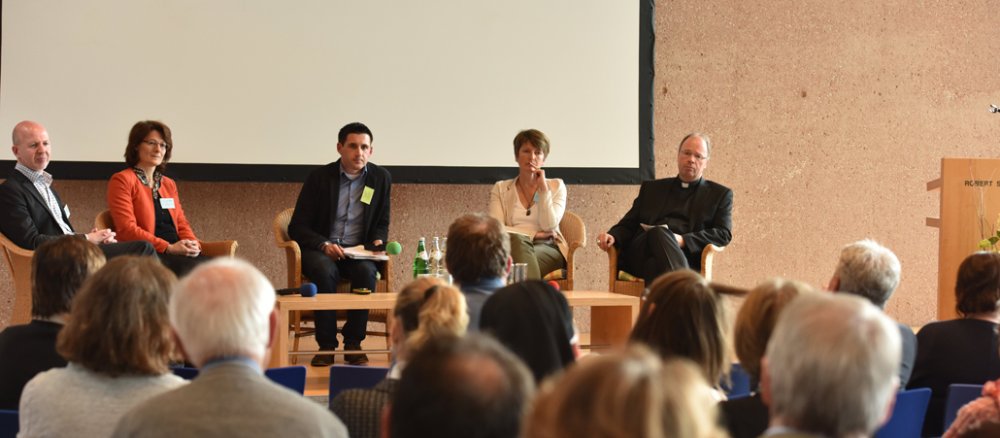 Teilnehmer der Trierer Synode diskutieren auf einem Podium.