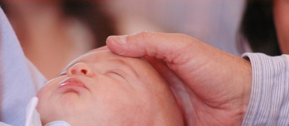 Ein Vater hält den Kopf seine Babys.