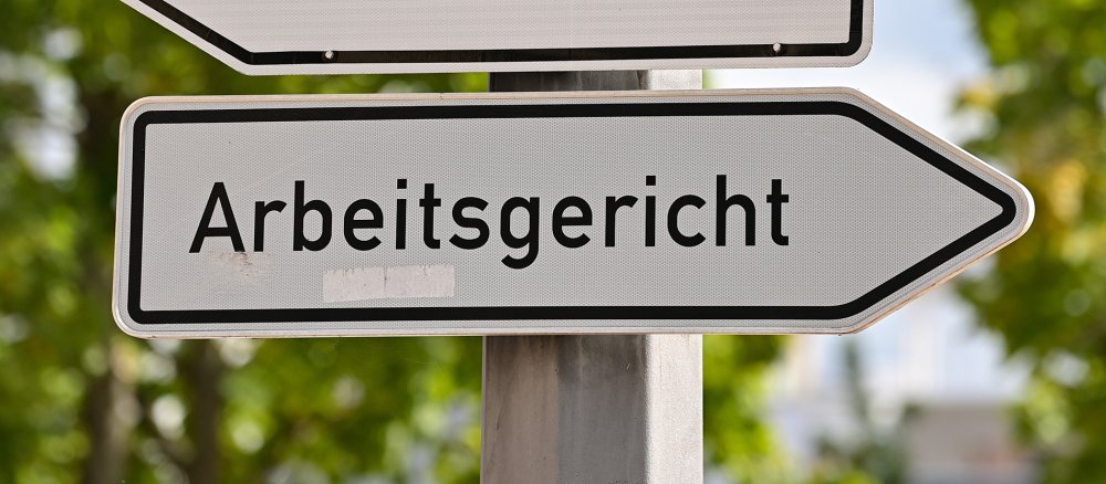 Ein Straßenschild zeigt den Weg zum Arbeitsgericht