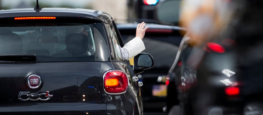 Ein schwarzer Fiat, heraus schaut die winkende Hand des Papstes