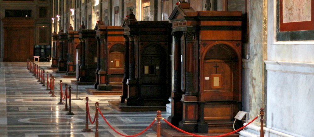 Leere Beichtstühle in der römischen Basilika Sankt Paul vor den Mauern warten auf Pönitenten.