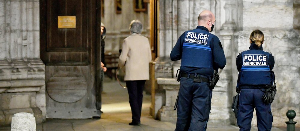 Polizisten patrouillieren vor einer Kirche