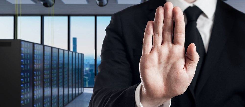 Eine Hand signalisiert vor einer Reihe von Servern: Stop, bis hierher und nicht weiter!