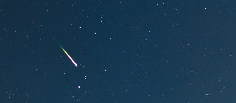 Eine Sternschnuppe ist am Himmel zu sehen.