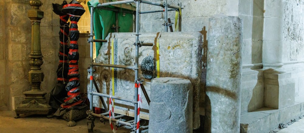 Baugerüst vor einer mittelalterlichen Steinplatte in der Grabeskirche