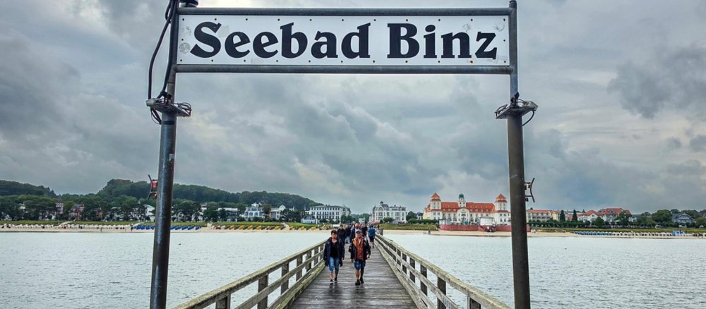 Ein Schild mit der Aufschrift "Seebad Binz" auf einem Steg.