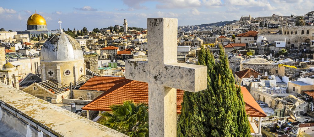 Blick auf Jerusalem. Im Vordergrund steht ein Kreuz.