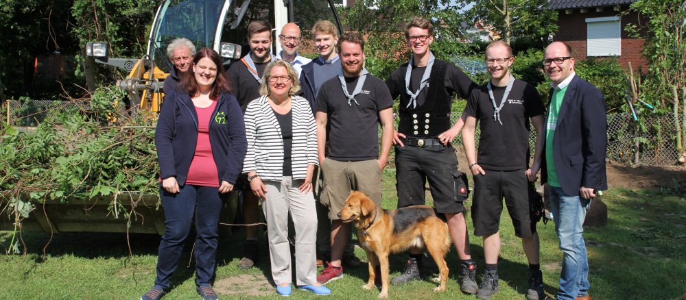 Bundesumweltministerin Svenja Schulze steht mit Pfadfindern aus Münster-Gievenbeck vor einem Bagger.