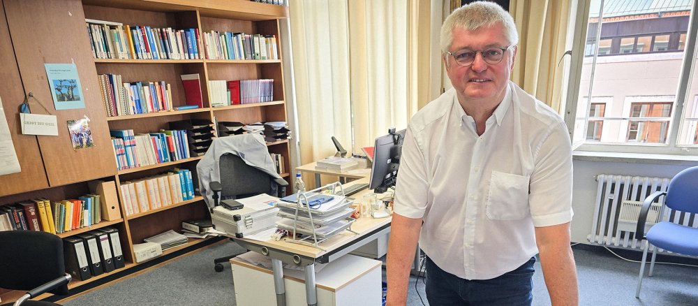Religionspädagoge Hans Mendl, Professor für Religionspädagogik und Didaktik des Religionsunterrichts an der Universität Passau, vor Büchern, deren Autor er ist, am 6. Juli 2026 in seinem Büro in Passau.