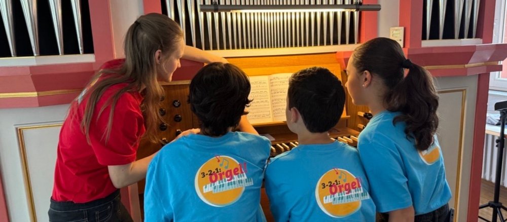 Seminarleitung Johanna Wimmer zeigt Kindern, wie man gemeinsam ein Stück der Orgel spielt.