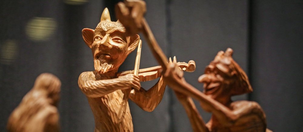 Aus Holz geschnitzte Teufelsfigur, die Geige spielt