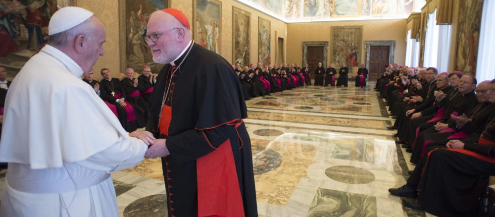 Kardinal Reinhard Marx und Papst Franziskus geben sich die Hand