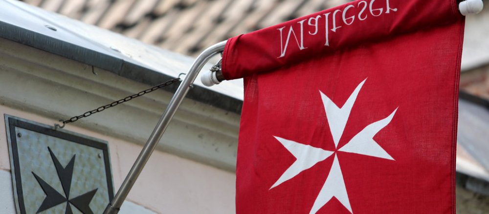 Eine rote Flagge mit einem weißen Kreuz.,