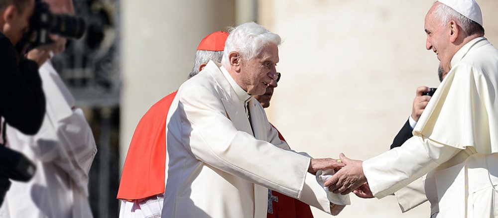 Benedikt XVI. und Franziskus geben sich die Hand.