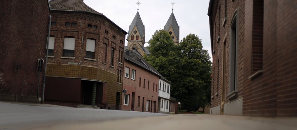 Leere Straße, Backsteinhäuser, Türme des Immerather Doms