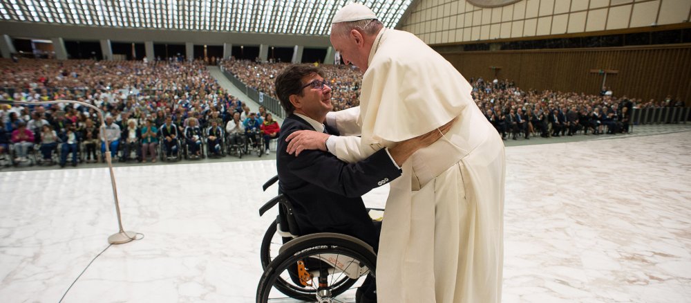 Papst Franziskus trifft mit einem Sportler im Rollstuhl zusammen.
