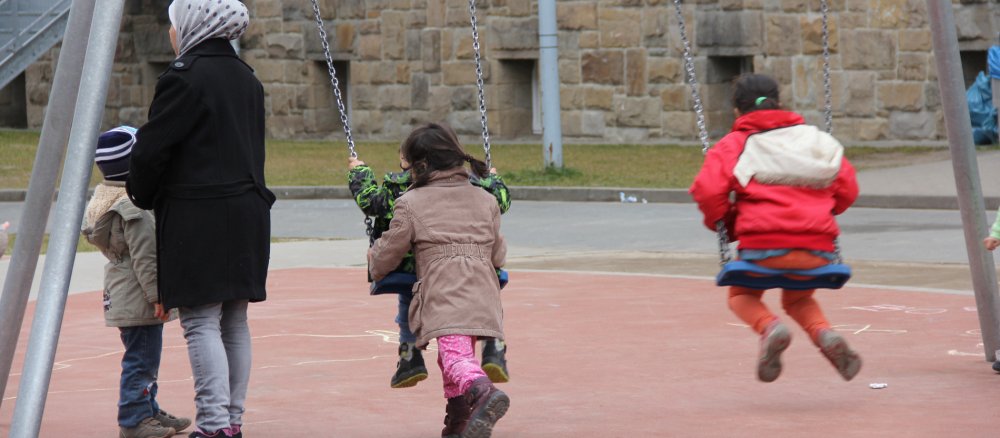 Schaukelnde Kinder in der Flüchtlingsunterkunft
