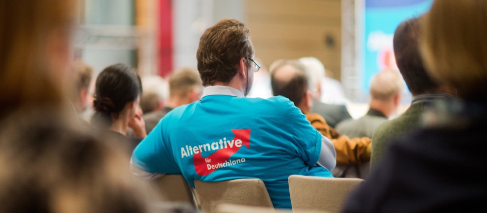 A man wears a T-shirt with the logo of the AfD party.
