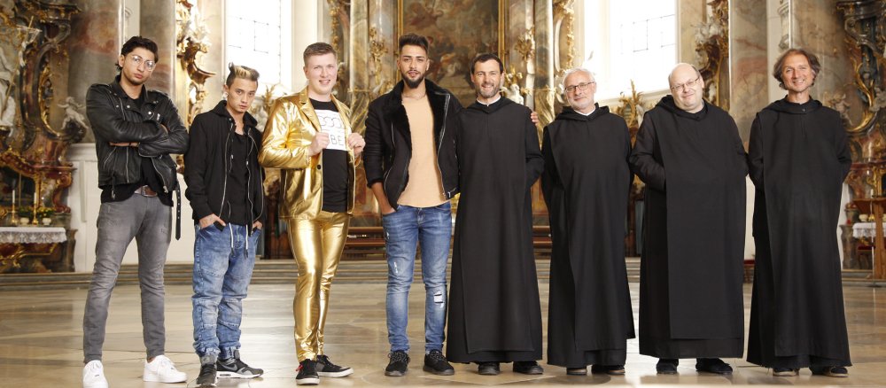 Die vier jungen Teilnehmer stehen neben vier Benediktinermönchen
