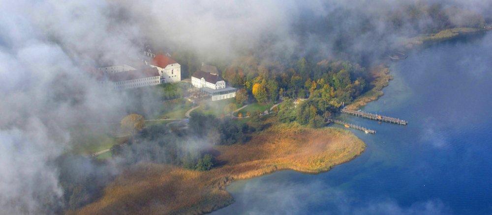 Das Augustiner-Chorherrenstift auf der Insel Herrenchiemsee erscheint unter den Wolken.