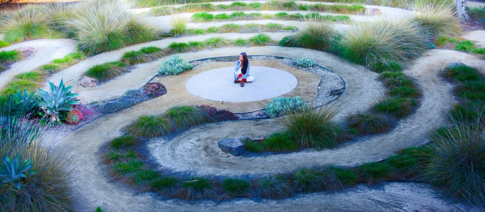 Eine Frau sitzt in der Mitte eines Labyrinths