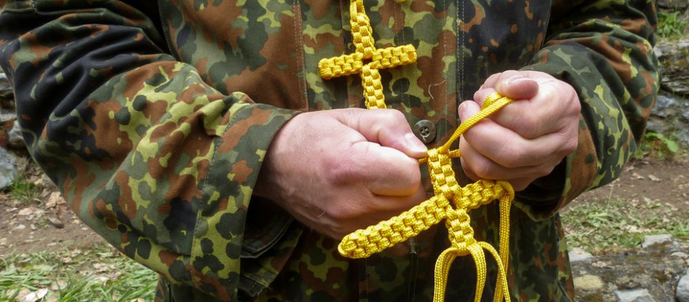 Oberstabsfeldwebel Franz Niedermüller knüpft in Lourdes ein Kreuz aus Schnur.