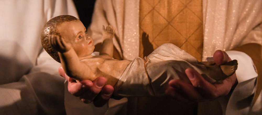 Der Priester hält das Christkind in den Händen