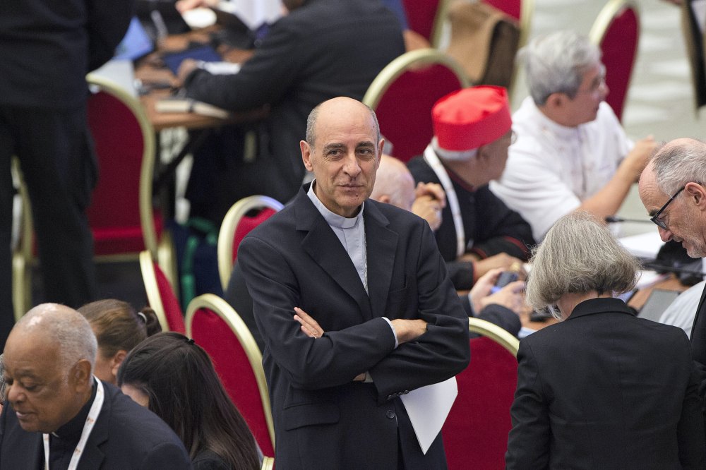 Kardinal Victor Manuel Fernandez steht mit verschränkten Armen in der Synodalaula