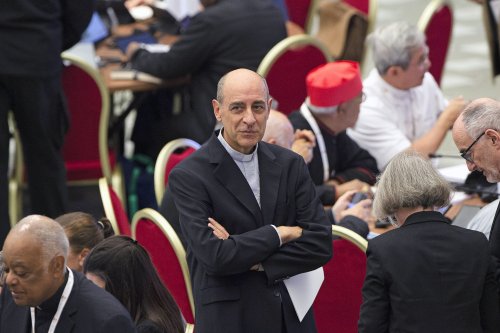 Kardinal Victor Manuel Fernandez steht mit verschränkten Armen in der Synodalaula