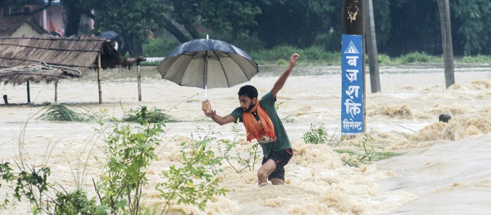 Ein nepalesicher Mann versucht im Hochwasser Halt zu finden.