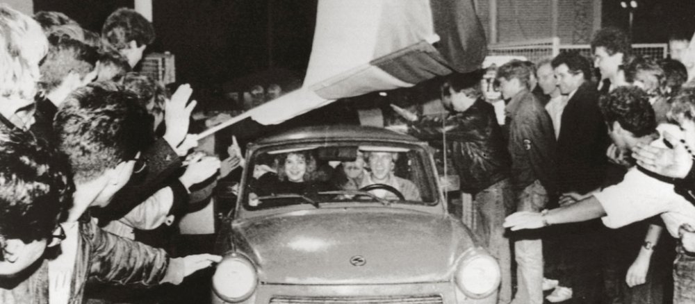 Trabbi der durch ein Menschenspalier fährt.