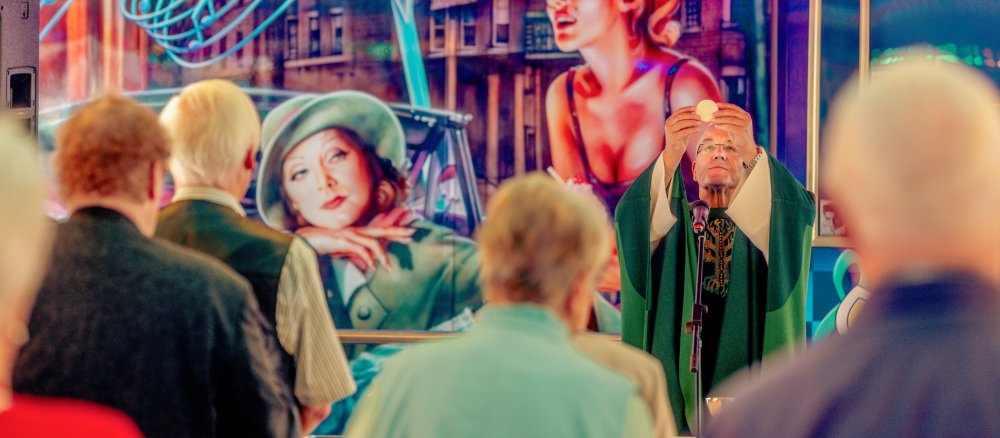 Ein Pfarrer feiert Eucharistie auf einem Autoscooter