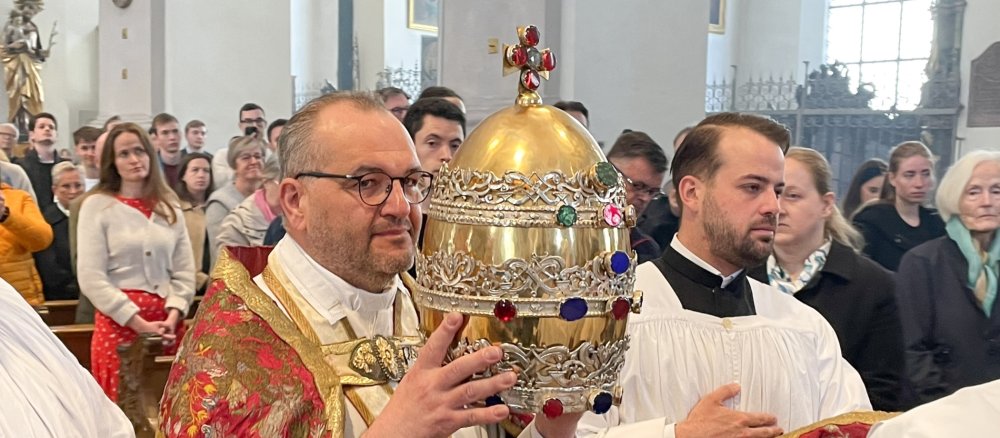 Daniel Lerch, Stadtpfarrer in München, trägt am 11. Mai 2025 die goldene Papstkrone durch die Stadtpfarrkirche Sankt Peter in München.