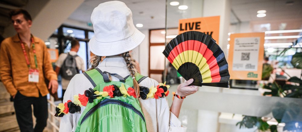 Pilgerin mit einem Fächer in den Deutschlandfarben im deutschen Pilgerzentrum beim Weltjugendtag in Lissabon
