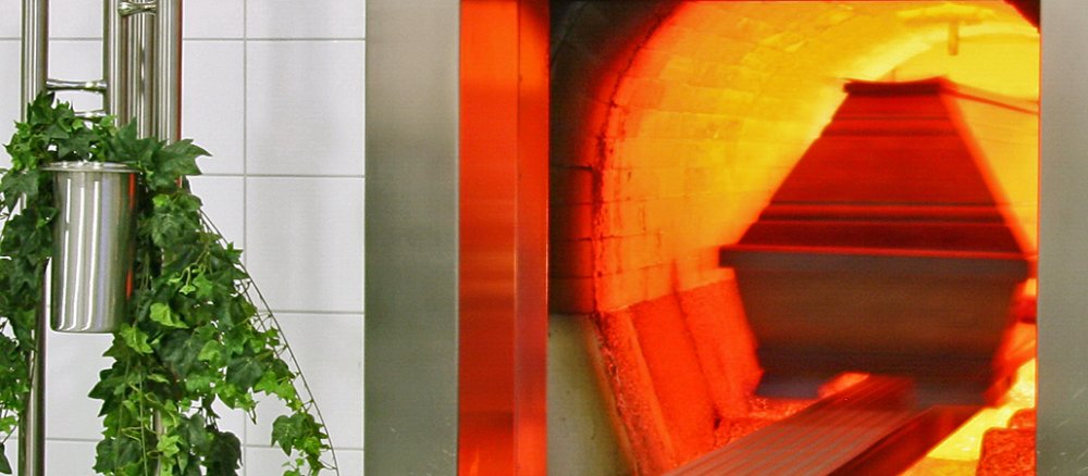 A body in a coffin is cremated in a cremation facility.