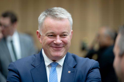 Ministerpräsident Gordon Schnieder lächelt im Gespräch einen Gesprächspartner an