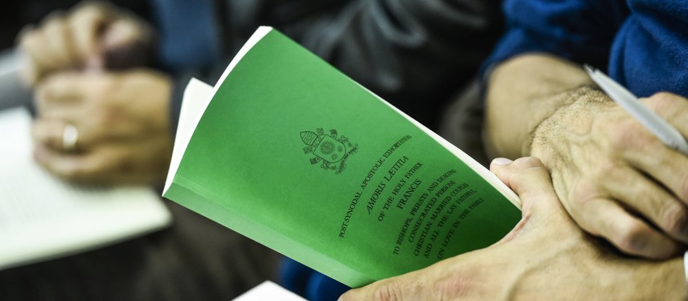 Ein Mann hält das Papstschreiben "Amoris laetitia" in der Hand