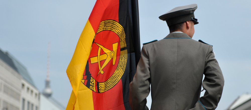 Eine DDR-Fahne wird am Freitag (13.08.2010), dem 49. Jahrestag des Mauerbaus, vor dem Brandenburger Tor in Berlin gehalten