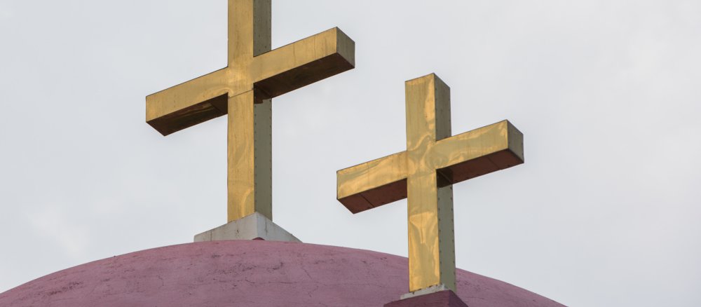 Zwei Kreuze auf einer Kirchenkuppel